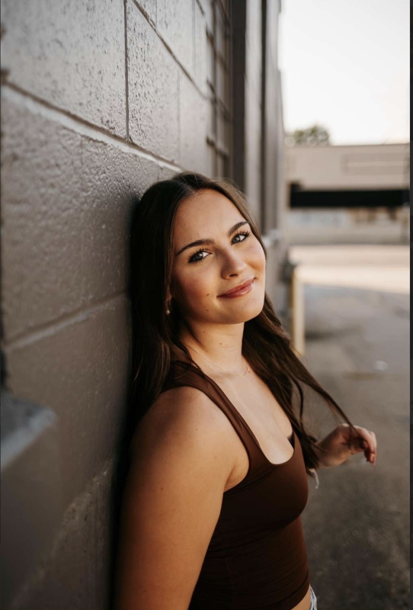 Alyse Burns smiles at the camera while her photographer directs her to pose